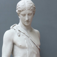 Plaster cast figure of a young man wearing only an animal skin draped over his naked chest